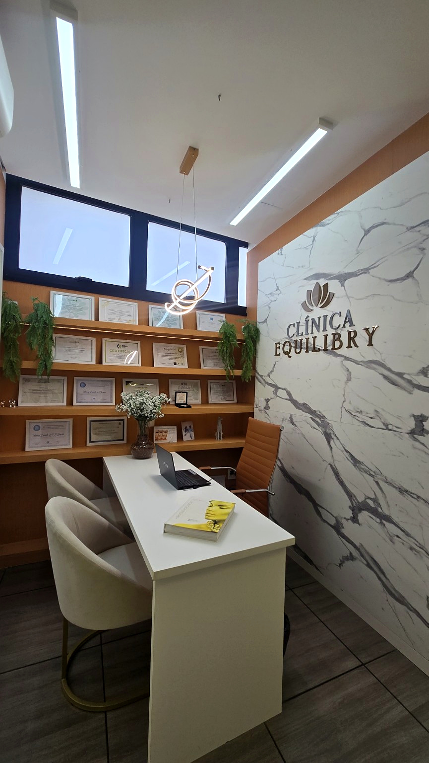 Ambiente da Clínica Equilibry: parede de mármore com a marca e certificações